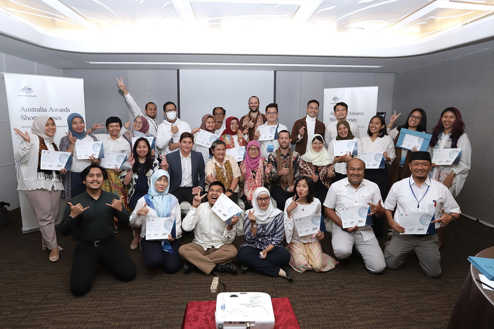 Los participantes del curso corto sobre financiamiento climático de los premios Australia toman una foto grupal que muestra su certificado de finalización